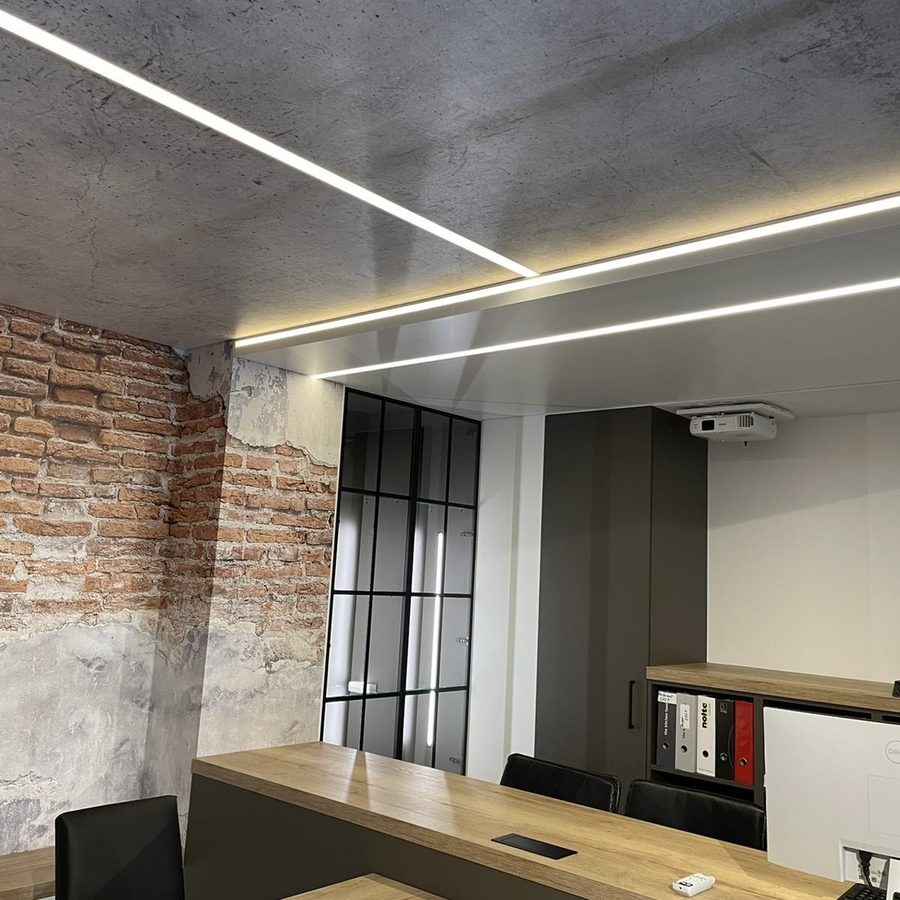 Spanndecke in Betonoptik mit integrierten LED-Lichtlinien im Büro